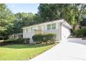 Landscaped front yard leading to a charming one-story home with a new concrete driveway at 3436 Adkins Nw Rd, Atlanta, GA 30331