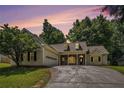 Single-story home with a two-car garage, manicured lawn, and inviting stone-accented entryway at dusk at 114 Arborwood Way, Temple, GA 30179