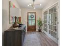 Welcoming entryway with wood floors, decorative light fixture, and stylish decor. French doors to the right at 1651 King Rd, Riverdale, GA 30296