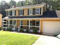 Inviting two-story home featuring black shutters, a covered porch, and an attached two-car garage at 2751 Herron Cir, Snellville, GA 30039