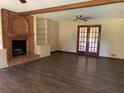 Spacious living room with a brick fireplace, wood floors, and french doors at 2751 Herron Cir, Snellville, GA 30039