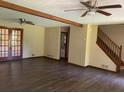 Open-concept living room featuring wood floors, exposed beams, and stairs to upper level at 2751 Herron Cir, Snellville, GA 30039