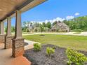 Inviting covered porch with brick-based columns and views of the landscaped front yard at 149 Elkins Blvd, Locust Grove, GA 30248
