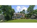 Charming two-story home with a manicured lawn, lush landscaping, and inviting front porch at 4020 High Gables E, Cumming, GA 30041