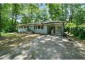 Picture of the home with a light blue painted brick facade, covered carport, and spacious driveway at 506 Bolijeri Blvd, Villa Rica, GA 30180