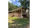 Charming house featuring a large covered porch and natural wood accents, set in a serene, wooded environment at 393 W Freeman St, Maysville, GA 30058