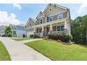 Street view of a lovely two-story home with a cozy front porch and a green lawn at 1618 Chancery Ln, Lithia Springs, GA 30122