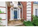 Inviting front entrance with blue door, brick facade, and manicured landscaping at 2866 Wynford Sw Dr, Marietta, GA 30064