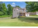 Well-maintained home with a covered porch, two-car garage, and expansive green lawn at 4160 Radford Oaks Ln, Cumming, GA 30028