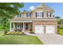 Charming two-story home with a covered front porch, brick accents, and well-maintained landscaping at 4160 Radford Oaks Ln, Cumming, GA 30028