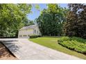 Long driveway leading to a three-car garage, surrounded by well-maintained lawn and trees at 629 Pine Ter, Canton, GA 30114