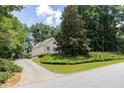 Exterior view featuring a long driveway surrounded by landscaping and large trees at 629 Pine Ter, Canton, GA 30114