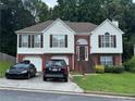 Charming two-story home with a brick and white exterior, a two-car garage, and a well-maintained front yard at 4192 Rhinehart Dr, Austell, GA 30106