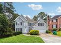 Two-story home with a well-manicured lawn, lush greenery, and attached garage at 4467 Boatmans Cv, Stone Mountain, GA 30083