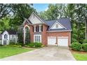 Charming brick home featuring a two-car garage, lush landscaping, and a well-manicured lawn at 2200 Major Loring Sw Way, Marietta, GA 30064
