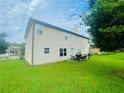 Large backyard with green grass, outdoor seating, and the back of a beige house on a sunny day at 2545 Melville Pl, Powder Springs, GA 30127