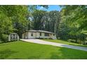 Angled view of home with long driveway and storage shed on a landscaped lawn at 4291 Lamar Street St, Decatur, GA 30035