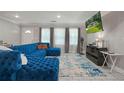 Bright living room featuring a plush blue sectional sofa, neutral paint, and light tile flooring at 4291 Lamar Street St, Decatur, GA 30035