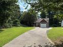 Long driveway leading up to a brick home, surrounded by lush trees and greenery at 8113 Fieldstream Way, Douglasville, GA 30134