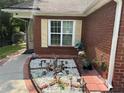 Close up of decorative front yard area outside this brick home with tan shutters at 8113 Fieldstream Way, Douglasville, GA 30134