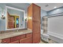 Well-lit bathroom featuring a granite vanity, ample storage, and shower with a gray and white striped curtain at 620 Glen Iris Ne Dr # 206, Atlanta, GA 30308