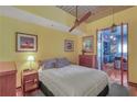 Bedroom with ceiling fan, yellow walls, artwork, and view of the open kitchen area at 620 Glen Iris Ne Dr # 206, Atlanta, GA 30308