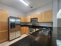 Galley kitchen featuring stainless steel appliances, dark countertops, and ample cabinet space at 870 Mayson Turner Nw Rd # 1228, Atlanta, GA 30314