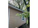 Exterior view of home showing tan siding and a white framed window at 1566 Avon Sw Ave, Atlanta, GA 30311