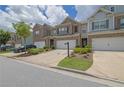 Street view of well-kept townhomes featuring attached garages and manicured front yards on a sunny day at 2638 Village Park Bnd, Duluth, GA 30096
