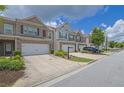 Street with attractive townhomes featuring brick accents, one-car garages, and manicured landscaping at 2638 Village Park Bnd, Duluth, GA 30096