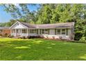 Charming house featuring a white brick facade, a welcoming front porch, and a well-maintained lawn at 3999 Phils Ct, Tucker, GA 30084