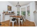 Bright dining room featuring hardwood floors, a rustic wood table with seating for six, and natural light from large windows at 1115 Manor Nw Way, Kennesaw, GA 30144