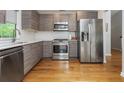 Modern kitchen with stainless steel appliances, sleek cabinetry, subway tile backsplash, and beautiful hardwood floors at 1115 Manor Nw Way, Kennesaw, GA 30144