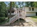 Charming white two-story home featuring a spacious front deck and stone accents, surrounded by lush trees at 3038 Skidaway Ct, Stone Mountain, GA 30087