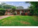 Quaint single story home featuring a covered carport and lush green lawn with mature trees at 44 Aberdeen St, Atlanta, GA 30307
