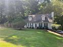 Lovely home with a well-manicured lawn, surrounded by lush greenery, and a glimpse of a car in the driveway at 1005 Timbervale Ln, Lithonia, GA 30058