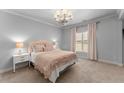 Comfortable bedroom with neutral decor, including a plush bed, side tables, and natural light at 5507 Aviemore Ct, Suwanee, GA 30024