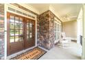 Welcoming front porch featuring double doors, brick accents, and cozy rocking chairs for relaxing at 1432 Arbor Bluff Ct, Lawrenceville, GA 30045