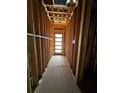 Hallway in construction with exposed wooden beams and a modern multi-panel door at the end at 314 Fortune Ne St # B, Atlanta, GA 30312