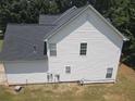 Exterior view of a home featuring white siding, a dark roof, and lush greenery at 856 Haydens Rdg, Ellenwood, GA 30294