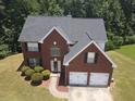 Charming two-story red brick home featuring a two-car garage and well-manicured lawn at 856 Haydens Rdg, Ellenwood, GA 30294