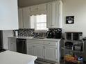 Well-lit kitchen features white cabinets, stainless steel appliances, and patterned backsplash for a modern and clean design at 4209 Resheemah St, Atlanta, GA 30349