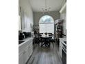 Bright eat-in kitchen featuring a round dining table set beneath a modern chandelier and a large arched window at 4209 Resheemah St, Atlanta, GA 30349