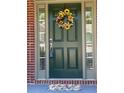 Charming front door adorned with a sunflower wreath, complementing the brick facade and welcoming entryway at 727 Pear Grove Pl, Marietta, GA 30066