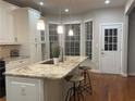 Spacious kitchen island featuring granite countertops, pendant lighting, and barstool seating area at 727 Pear Grove Pl, Marietta, GA 30066