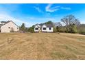 A modern white farmhouse situated on a spacious lot with lush greenery and clear skies at 81 Bridgemill Dr, Douglasville, GA 30134