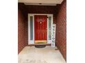 Close-up of a vibrant red front door with sidelights, framed by brickwork and a welcoming sign at 15 Fairwoods Ct, Covington, GA 30016