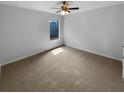 Empty bedroom featuring neutral colored walls and carpet and a ceiling fan at 324 Stoney Hollow Rd, Canton, GA 30114