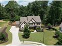 Beautiful house with mature landscaping, long driveway, and privacy fence surrounding the large backyard at 538 Mulberry Fern Dr, Auburn, GA 30011