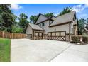 Spacious three-car garage featuring decorative doors and an expansive driveway for additional parking at 538 Mulberry Fern Dr, Auburn, GA 30011